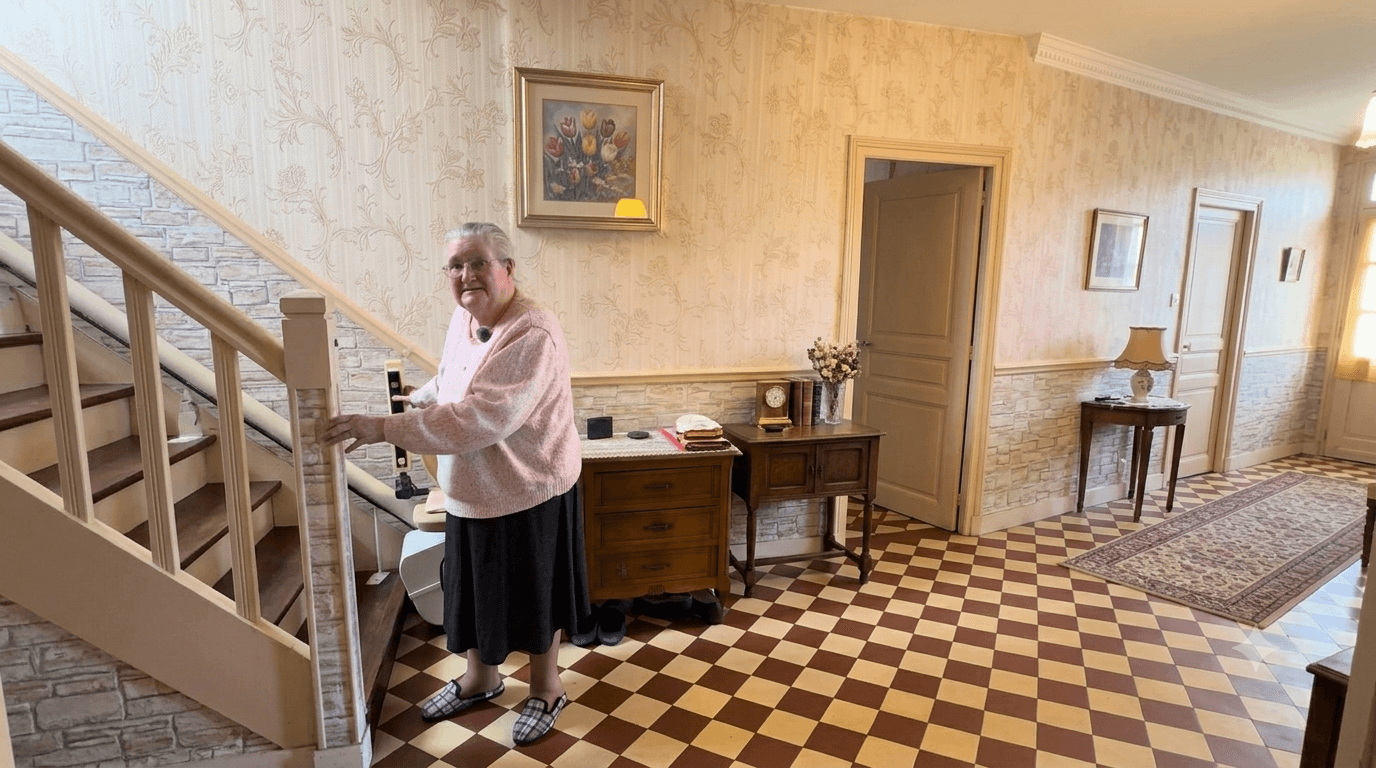 Une dame âgée se tenant à la rampe d'un escalier, dans une entrée au sol à damier